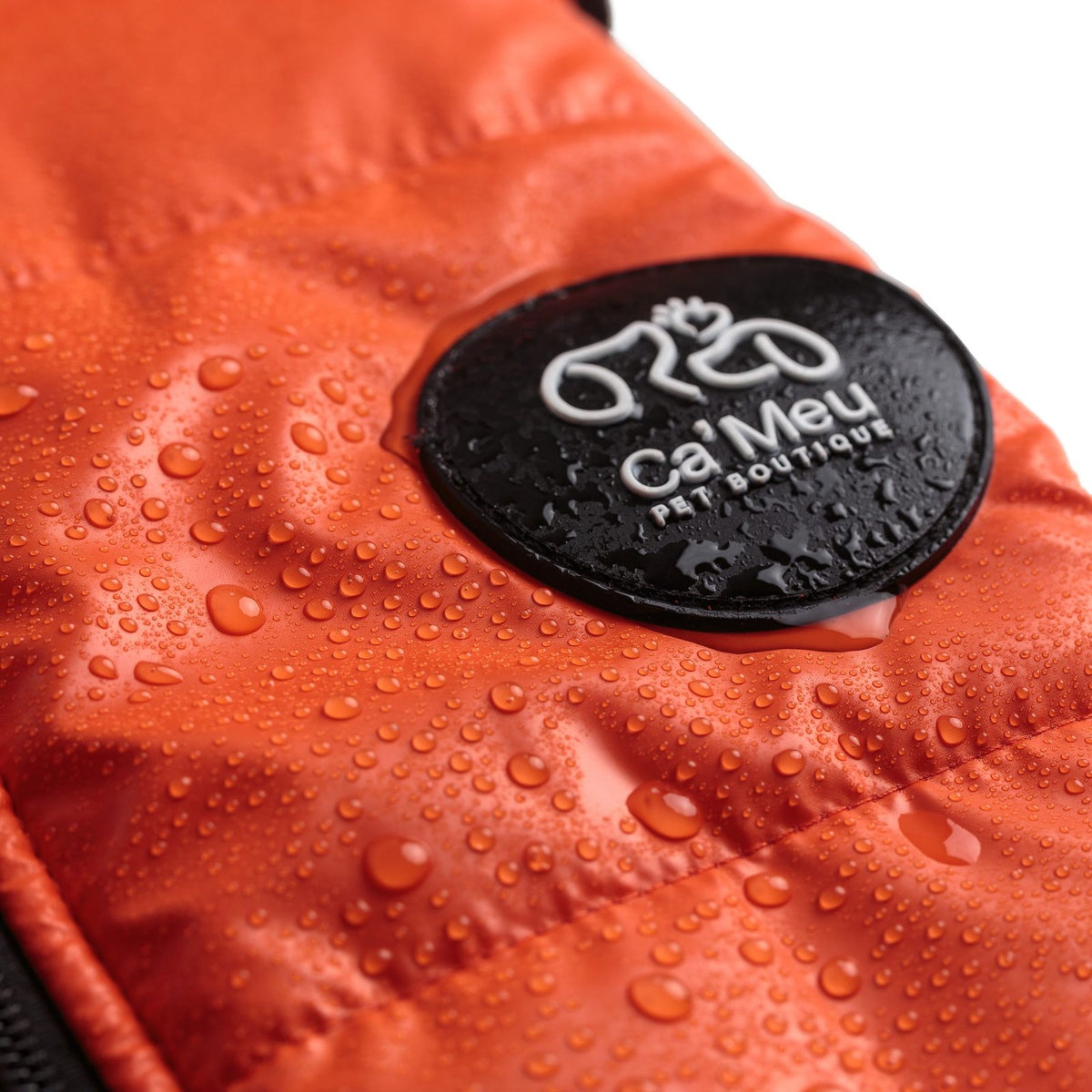 Gotas de água sobre o colete térmico laranja e o emblema Ca'Meu
